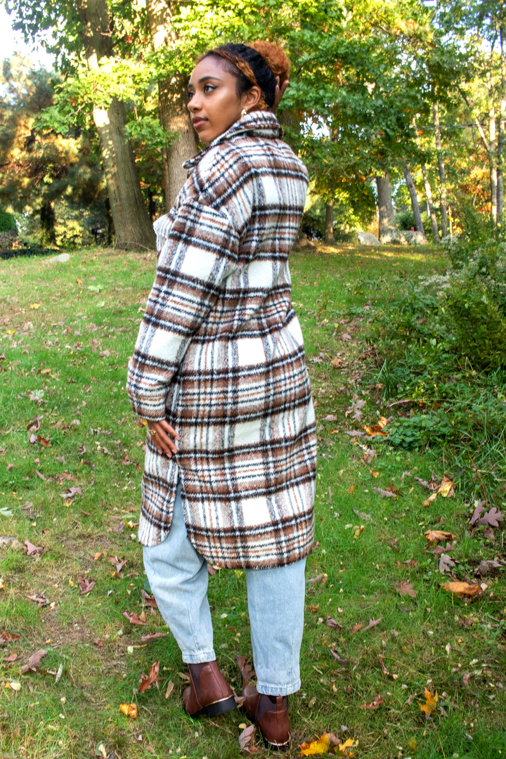 White mid length shacket coat with black and brown plaid detailing. Black buttons and collared neck.
