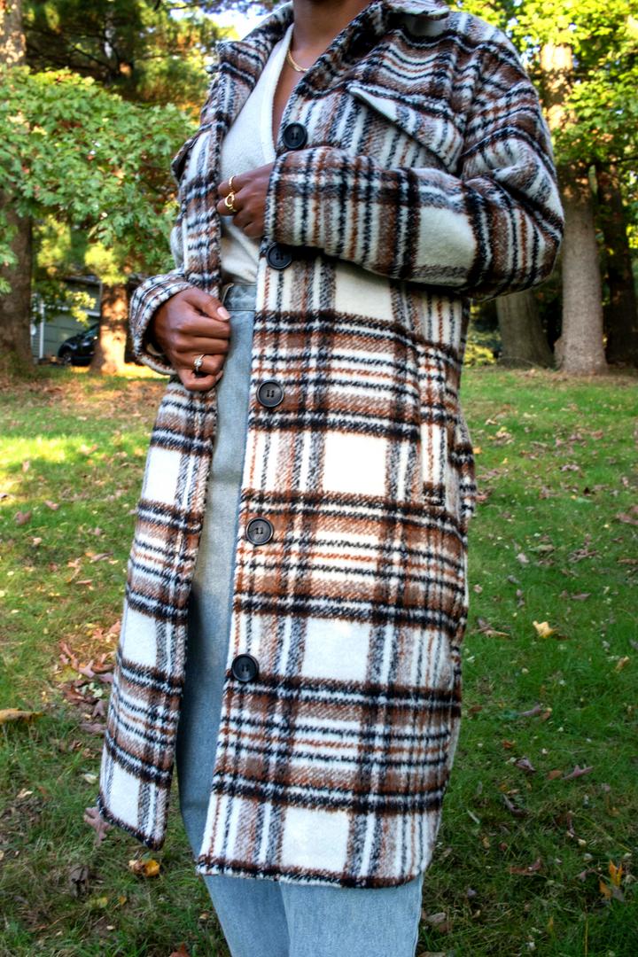 White mid length shacket coat with black and brown plaid detailing. Black buttons and collared neck.